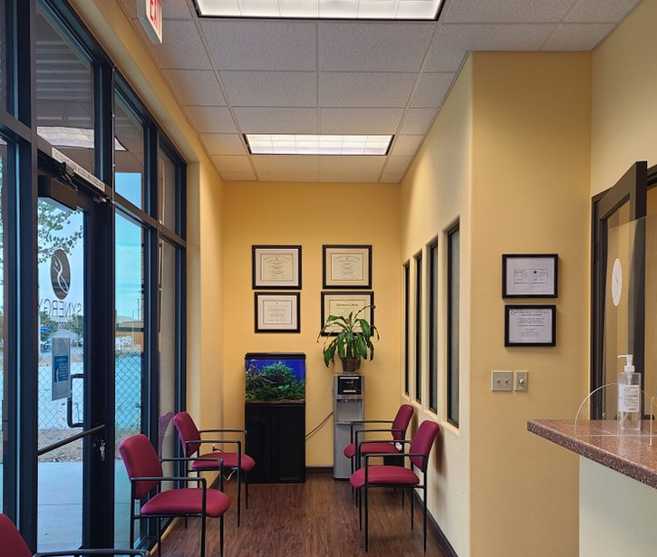 Bright yellow dental office waiting room with burgundy chairs and modern furnishings