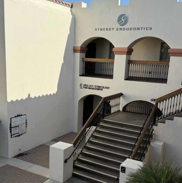 Synergy Endodontics building exterior with stairs, arched windows, and signage.